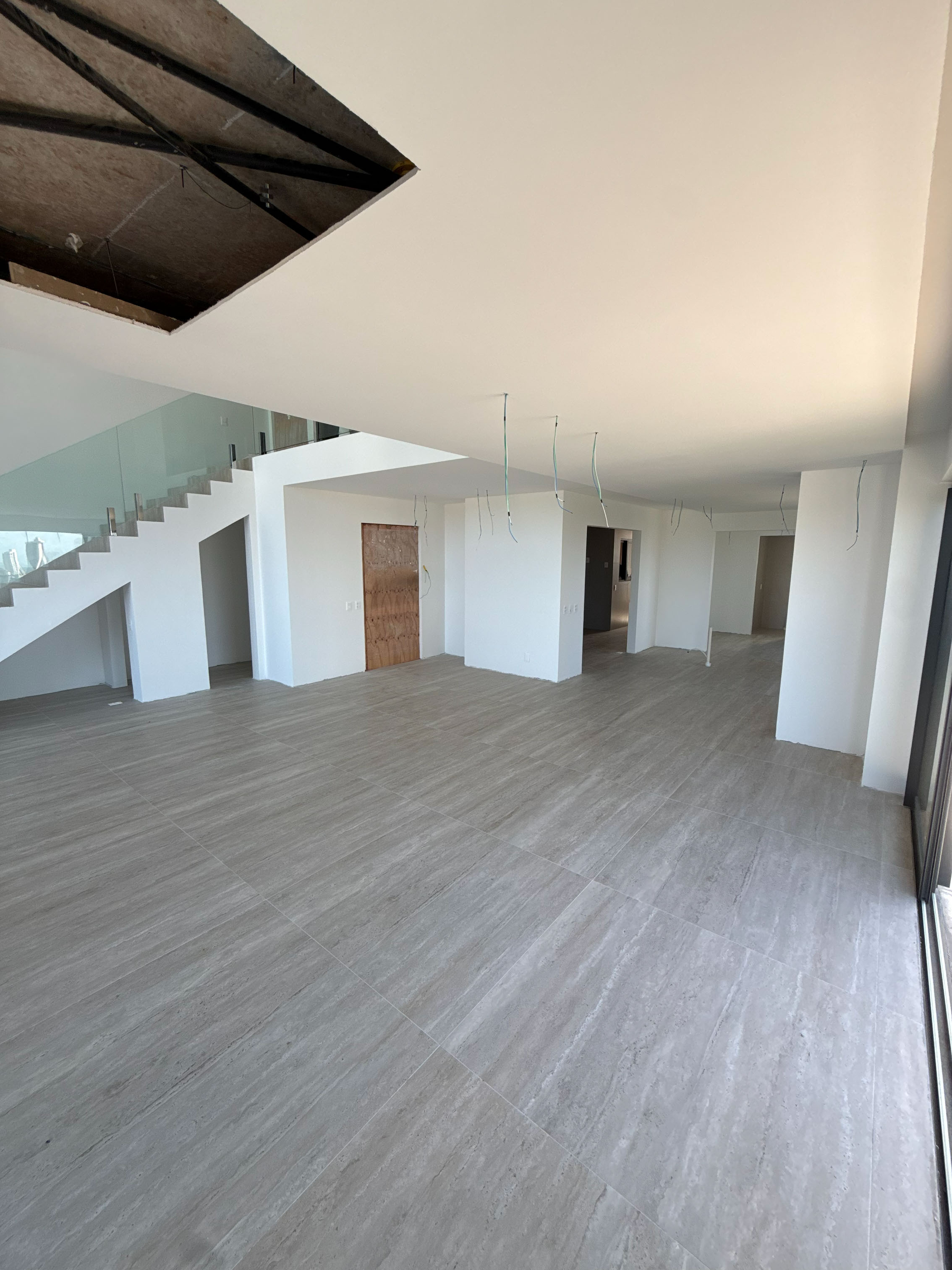 Ambientes internos do imóvel em estado real, inacabado, com paredes e piso sem revestimento final