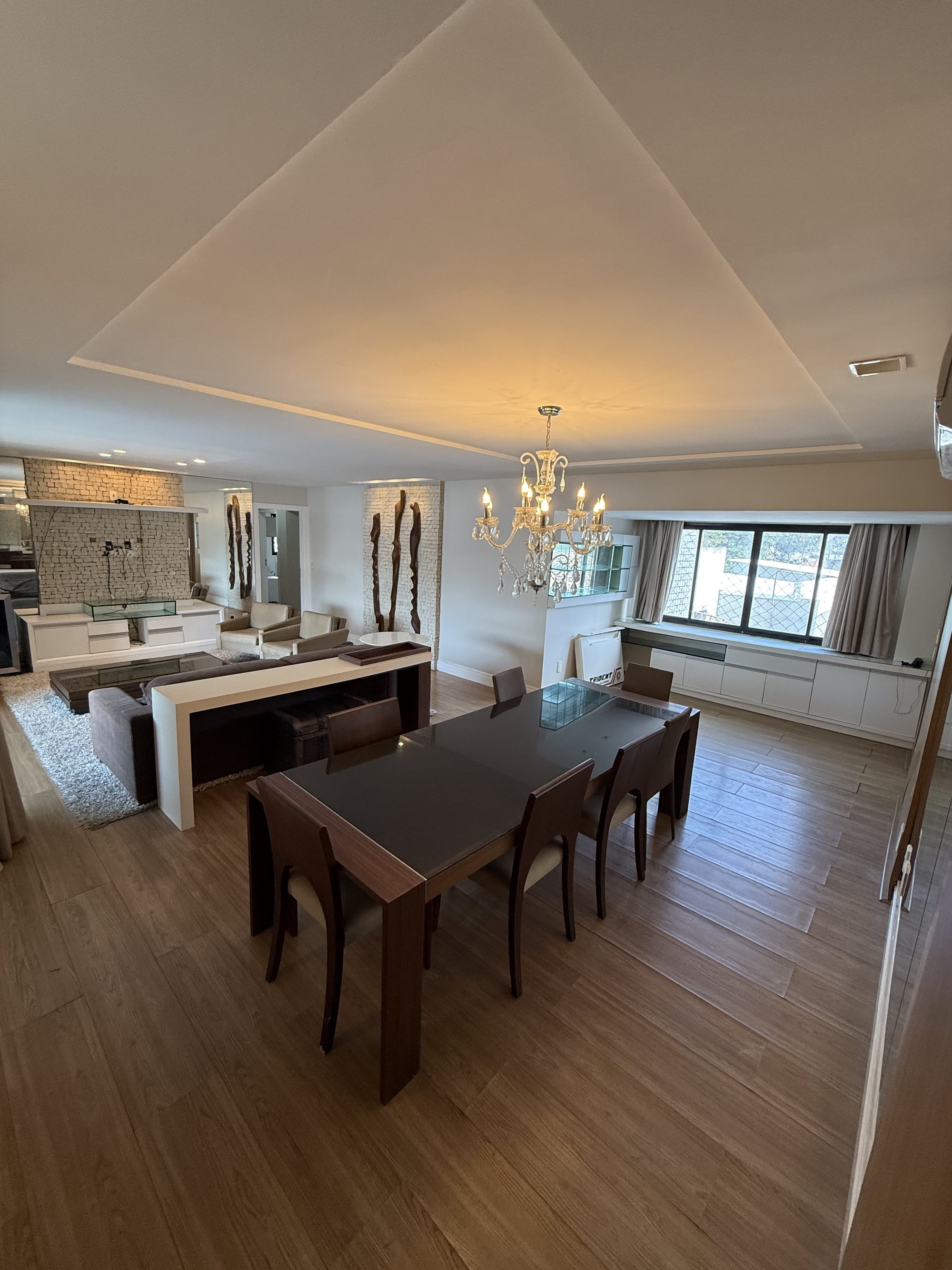 Sala de jantar do apartamento no Residencial Amadeus Mozart, com lustre e mesa para grupos grandes