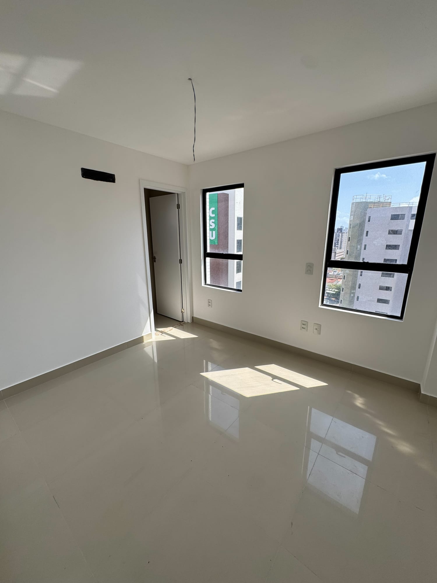 Suíte do apartamento Graciliano Ramos, com janela ampla e vista da região
