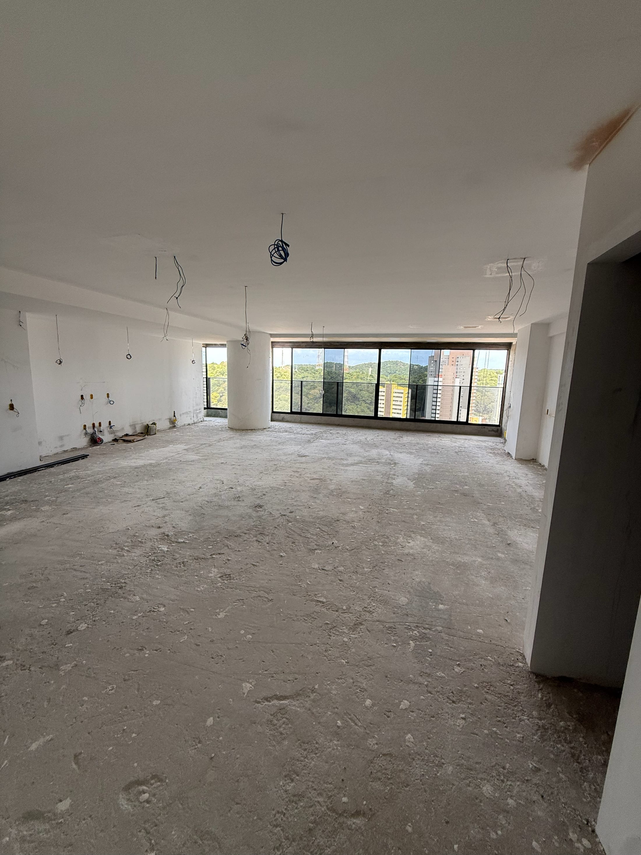 Sala de estar e jantar do Hermes em seu estado real de entrega, no bruto, com esquadrias instaladas e vista aberta para Natal
