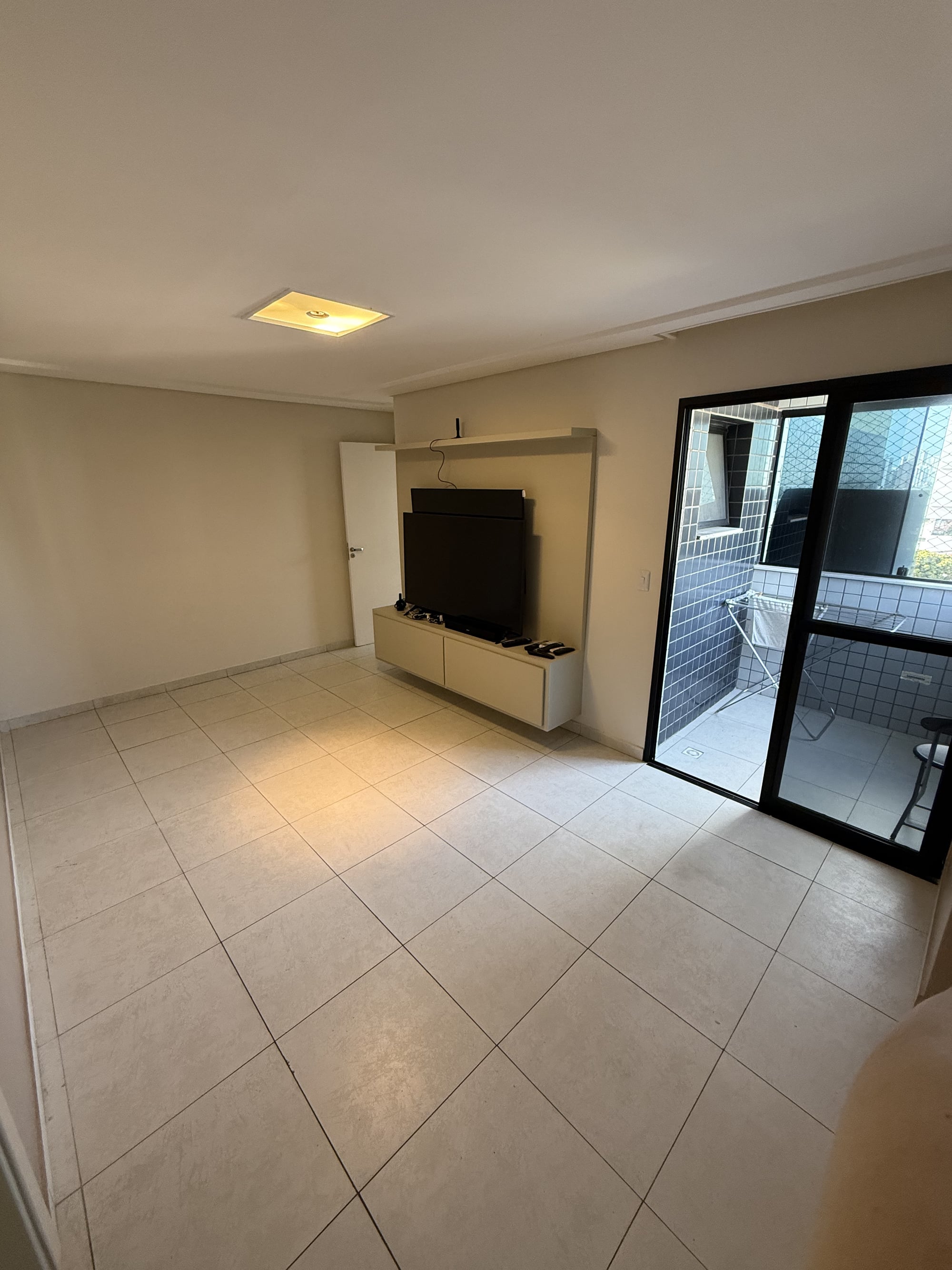 Sala do apartamento no Edifício Lourdes Lamartine, com porta de vidro para a varanda